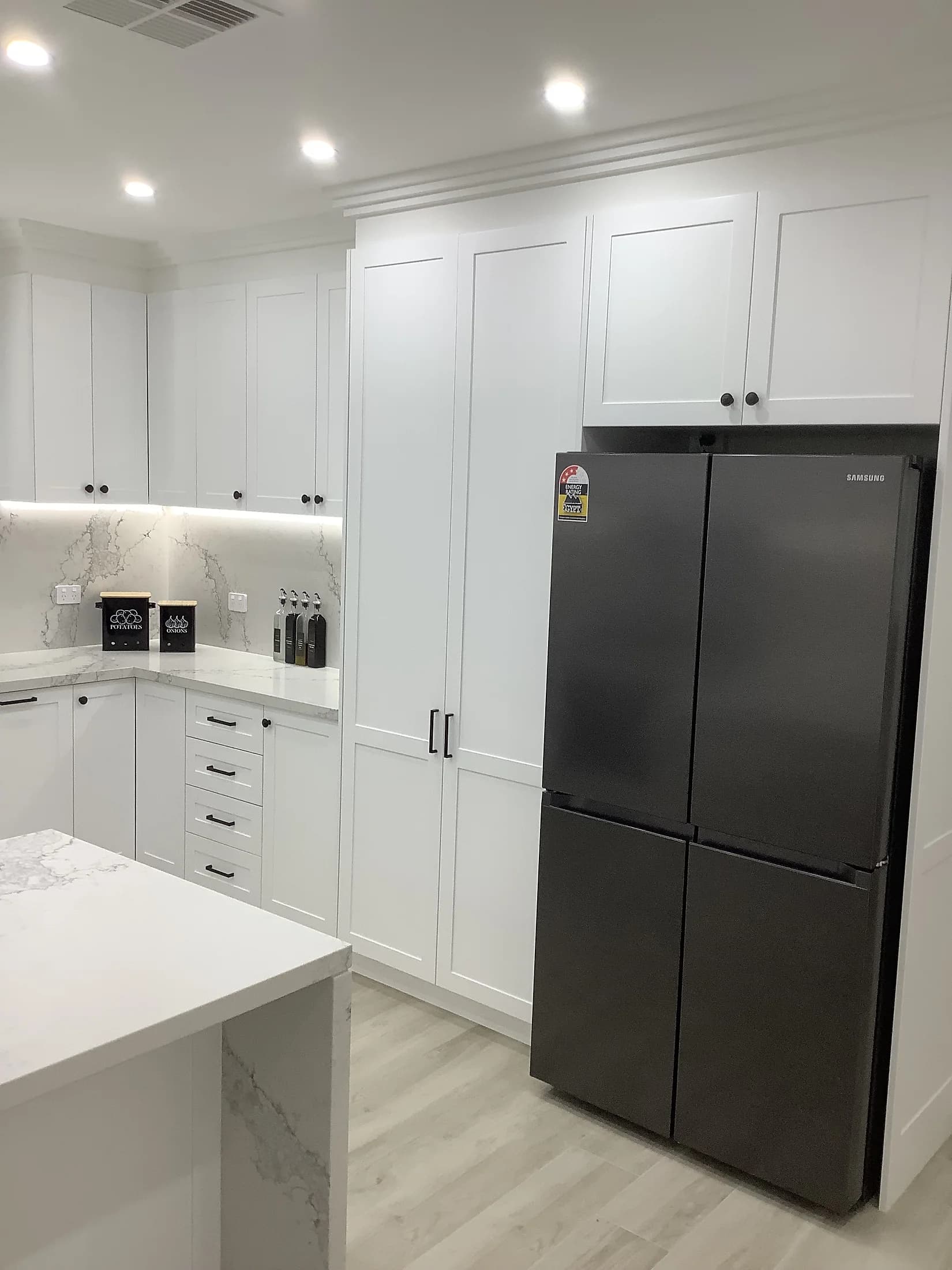 Custom kitchen cabinetry and stone-look surfaces by H&R Kitchens