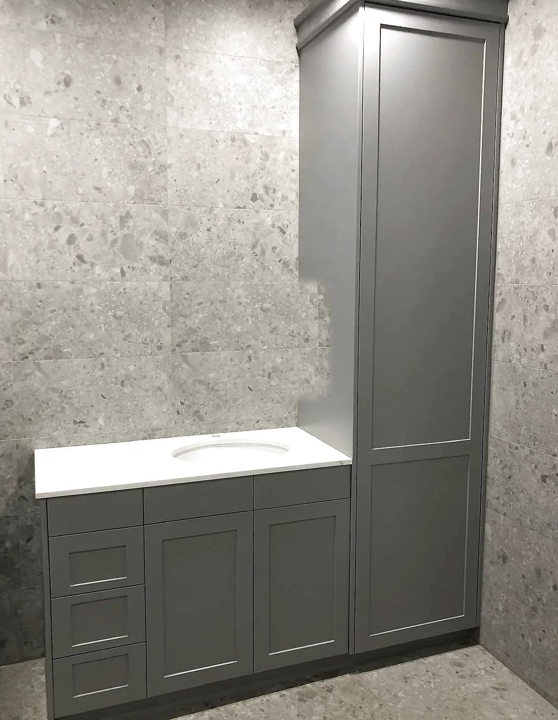 Bathroom vanity with a timber base, a white basin and a tiled wall by H&R Kitchens
