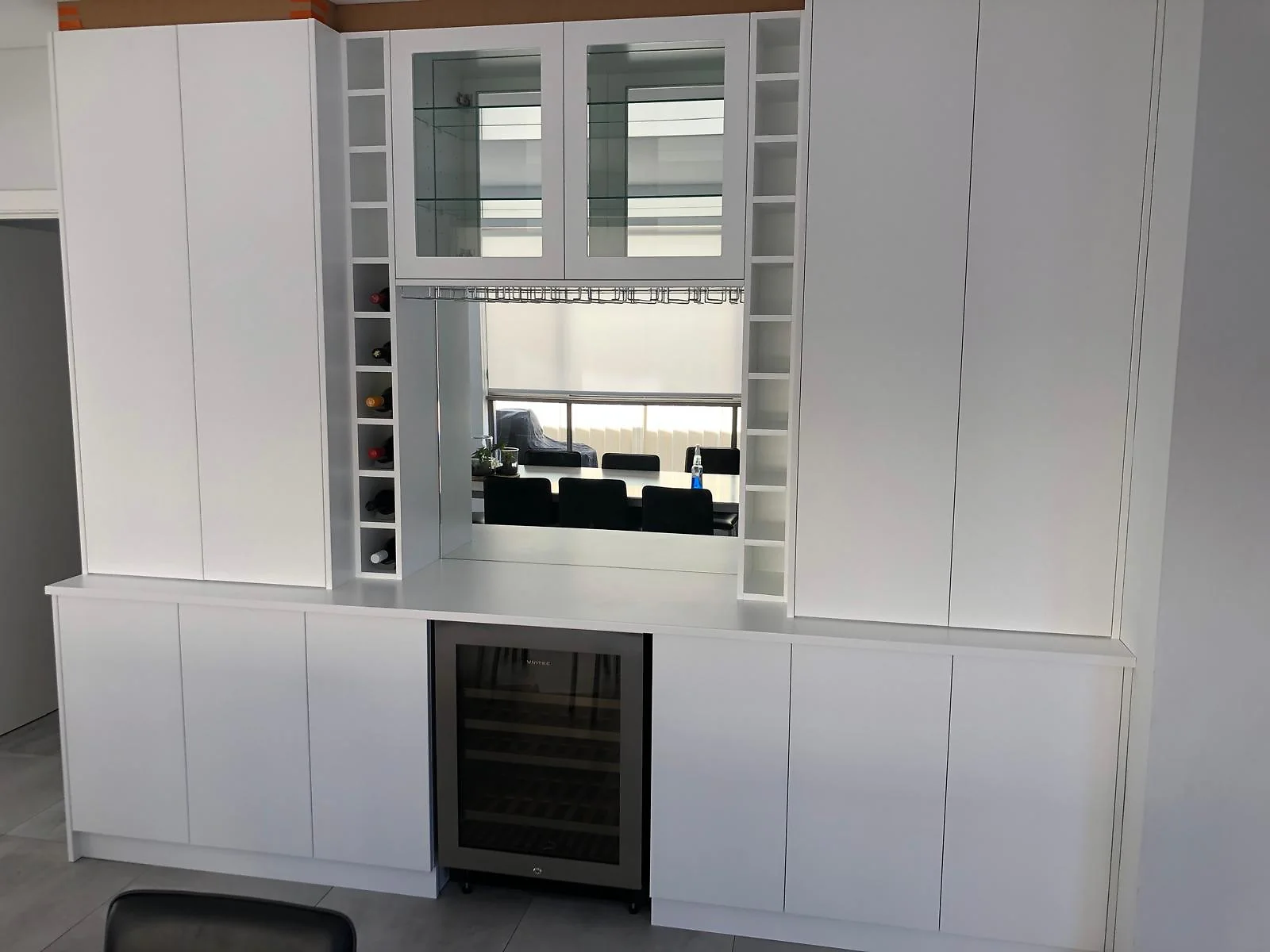 White butler's pantry joinery with glass uppers and a wine fridge, by H&R Kitchens