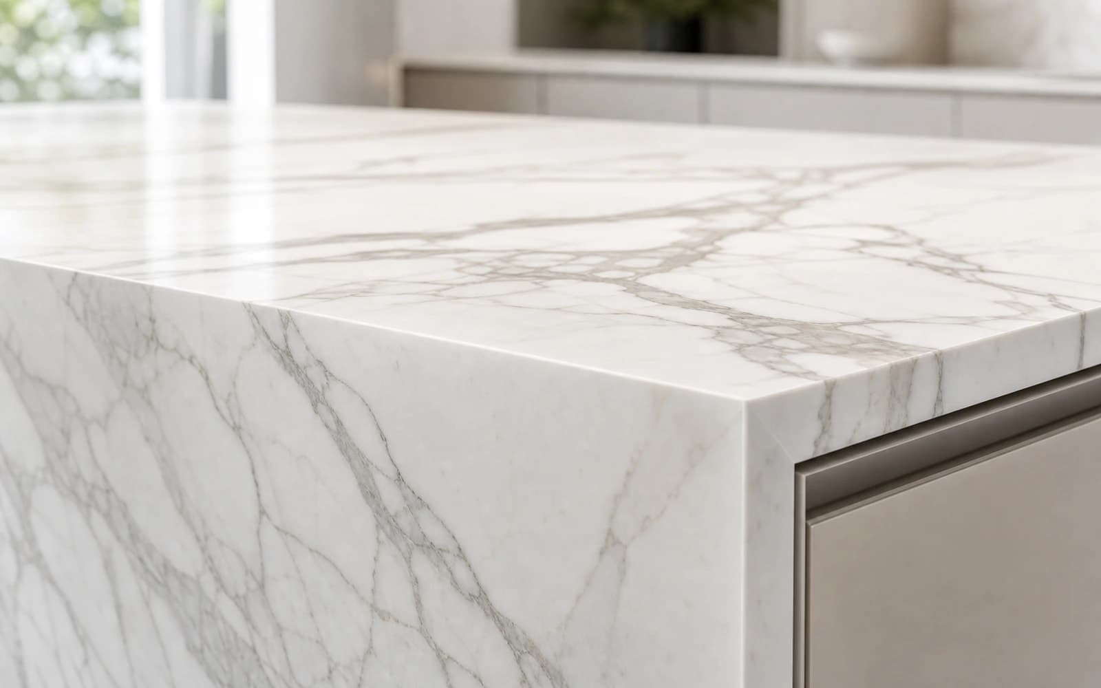 Close-up of a Calacatta-look marble benchtop with soft grey veining and a mitred waterfall edge